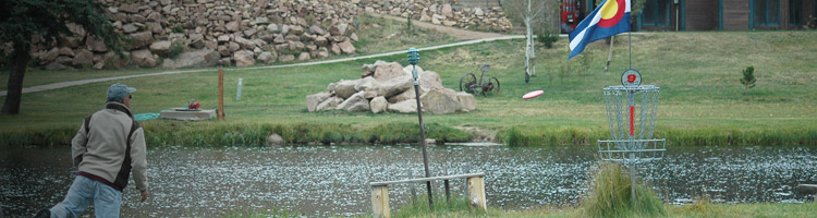 image of a disc golfer putting at a basket on the Beaver Meadows course in Red Feather Lakes, Colorado